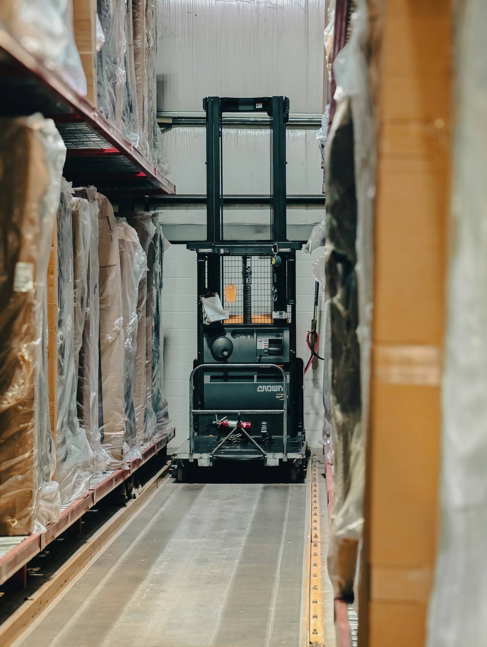 Distribution warehouse aisle with pallets and a forklift